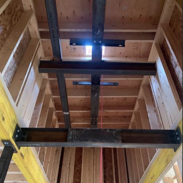  "Full-height hoistway beam integration. By performing a laser-survey of the shaft prior to fabrication, we accounted for a 3/4" plumbness variance, ensuring a first-time fit without on-site modifications."
