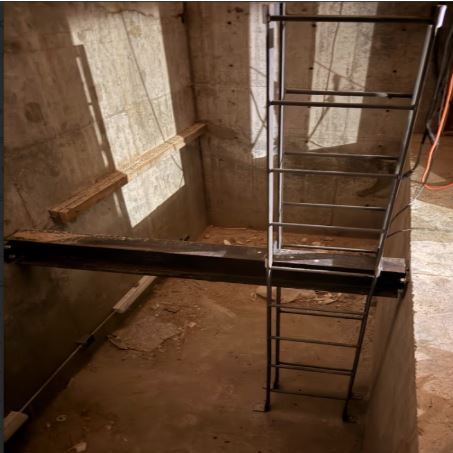 "Integrated Pit Kit installation. Includes CWB-certified ladders and safety-compliant buffer supports, all finished with shop-applied zinc-rich primer to meet ASME A17.1 standards."
