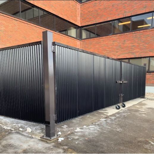 "Secure Multi-Unit Waste Enclosure: Custom-fabricated structural steel frame with heavy-duty corrugated infill panels. Features reinforced gate hinges and a dual-drop bolt locking system for high-frequency commercial use. Designed for maximum durability and site aesthetics while providing secure, weather-resistant containment for waste management assets."
